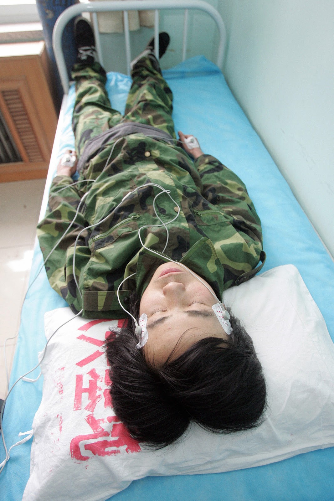 A Chinese teenager dressed in camoflage uniform of an internet addiction treatment "boot camp" is treated with low-voltage electrical jolts via pins inserted into the skin. (AFP/AFP/Getty Images)