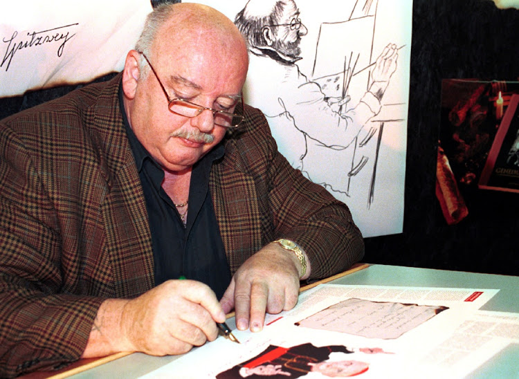 Konrad Kujau, the man who forged the Hitler diaries, signs specimen pages from a cookbook he compiled in Stuttgart. Sept. 23, 1998.