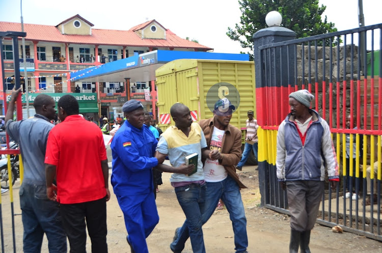 Two naked men who had climbed a tree preaching arrested by police at the Central Police Station in Nakuru on March 17, 2023.