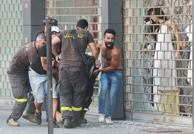 People evacuate a casualty after gunfire erupted in Beirut, Lebanon, October 14 2021. Picture: REUTERS/AZIZ TAHER