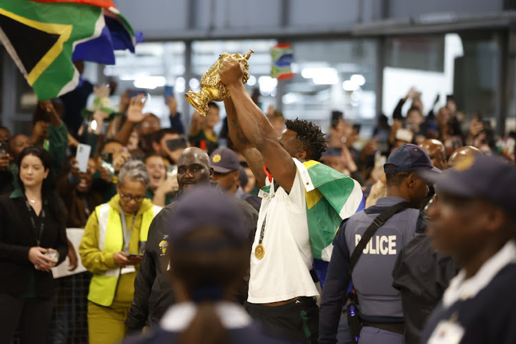 Springboks captain Siya Kolisi lifts the rugby world cup to a jubilant crowd at the OR Tambo international airport after arriving from conquering the championship in France. South Africans came in numbers at the airport to celebrate the team's victory.