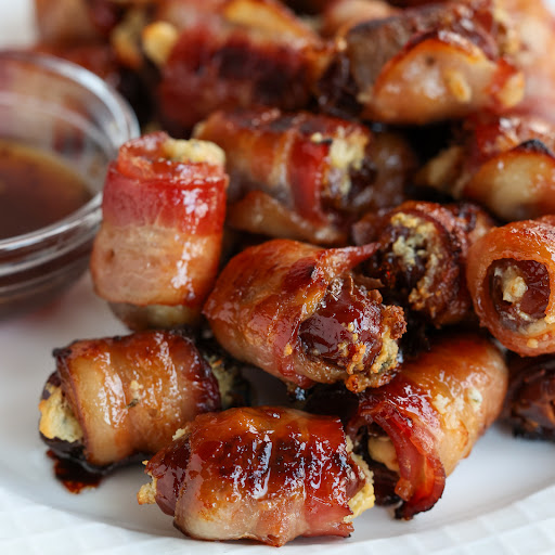 These easy to make Bacon Wrapped Dates are stuffed with herb cream cheese, wrapped in smoked bacon, and basted with a slightly spicy honey sauce