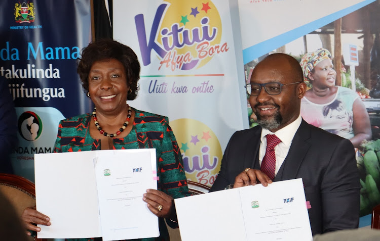 Kitui Governor Charity Ngilu and NHIF CEO Peter Kamunyo hold the documents they exchanged during the signing of a deal to provide subsidized health insurance cover to 85,000 households in Kitui county on Monday.