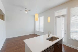 Center kitchen island with pendant lighting overlooking into the open living room with plenty of windows and natural light