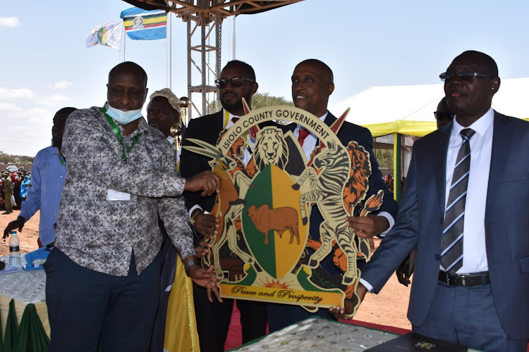 Isiolo Governor Abdi Hassan Guyo holding County coat of arm during the swearing in ceremony at the Isiolo Boys High School on August 25,2022.