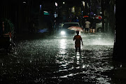 A boy wades through water as streets are flooded due to continuous rain, before the Cyclone Sitrang hits the country in Dhaka, Bangladesh, October 24, 2022.