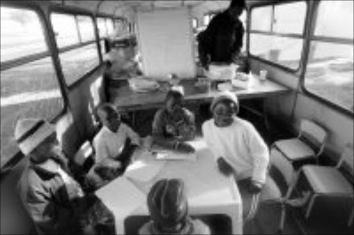 DOUBLING UP: Displaced xenophobia refugees go through their lives cooking, washing themselves, selling foodstuffs from their tents and learning from a disused double-decker bus at the Rand Airport camp in Germiston Ekurhuleni. Pic. Antonio Muchave. 12/06/08. © Sowetan.