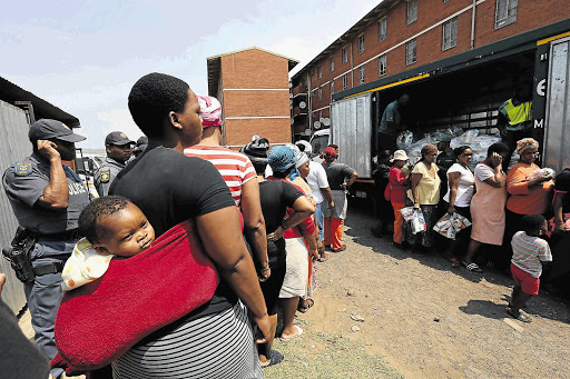 VICE GRIP: Women at Glebelands hostel in Umlazi line up for food and hygiene hampers donated by Gift of the Givers