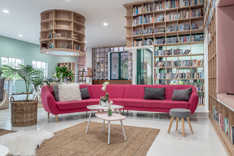 An informal seating area with a cheeky pink sofa encourages exchange and conversation in comfort.