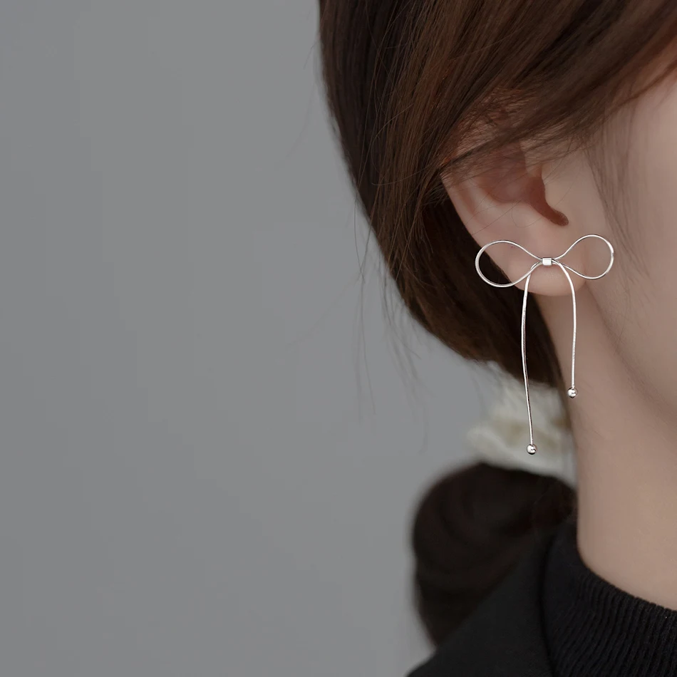 Eenvoudige glanzende strik-kwast oorstekers. Voeg een vleugje glamour toe aan je outfit met deze stijlvolle oorbellen.