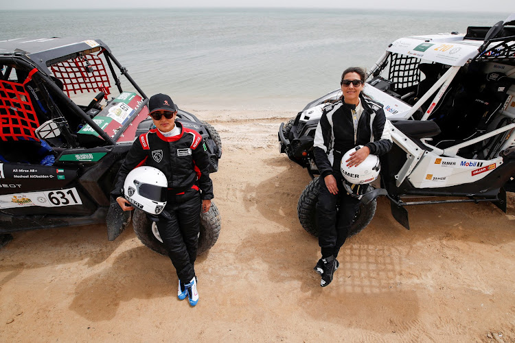 Saudi female rally drivers Mashael Nasser Al-Obaidan and Dania Akeel next to their Buggies during the first stage of Sharqiyah International Baja Rally in Dhahran, Saudi Arabia on March 5 2021.