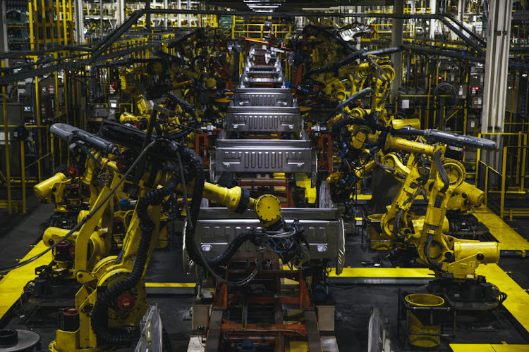 Robotic arms operate on the bed frame of a truck at the Ford Motor Co. Dearborn Truck Plant in Dearborn, Michigan, US.