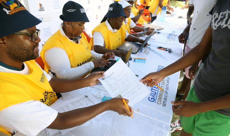 A Department of Community Safety employee hands over a form to a potential recruit. Picture: Ziphozonke Lushaba