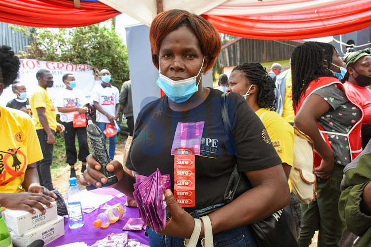 Community worker Christian Adhiambo holds a bunch of female condoms during World AIDS Day at Undugu grounds on 1, December 2021. PHOTO/MERCY MUMO