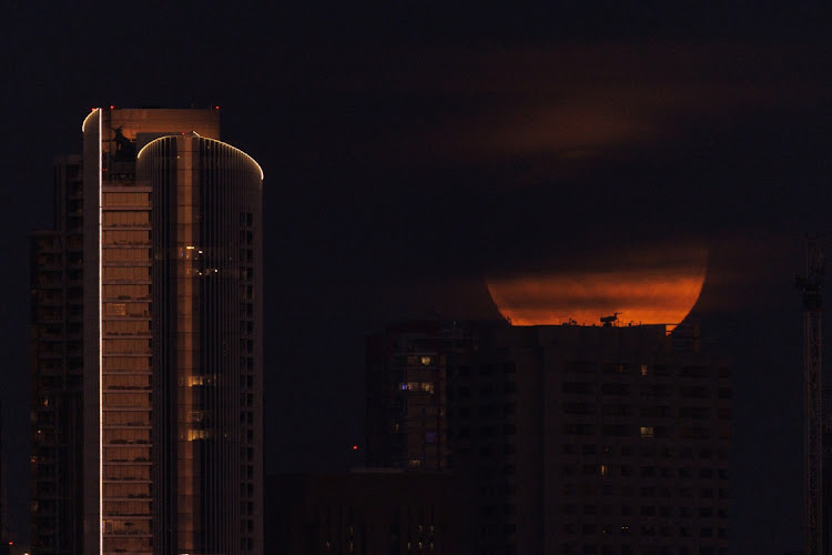 A super moon, known as the Blue Moon, is obscured by clouds as it rises above the city of San Diego, California, US, August 30, 2023.