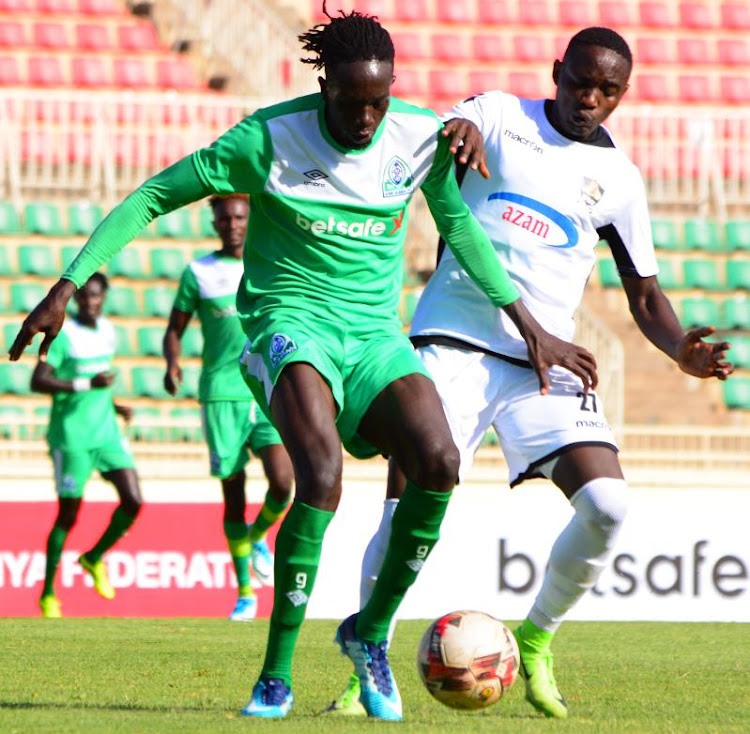 Gor mahia's Titto Okello (L) vies for the ball with Ruboneka Jean Bosco from APR of rwanda during their Caf Champions League preliminary round return leg at Nyayo Stadium.