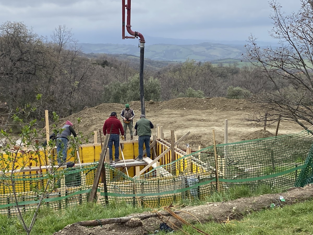 Workman pouring concrete on the site of Podere Santa Pia