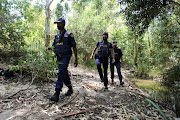 Atlas Security officials Tumi Semela, Bernadette Nel-Naude and Conrad Cloete search the bushy area close to the Baakens River after Wednesday’s brutal early-morning house robbery in PE.