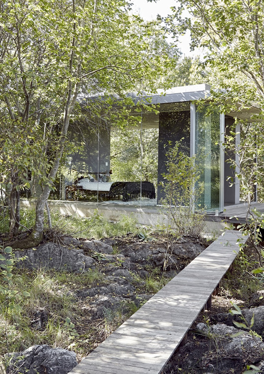 The bedroom seen from a boardwalk that leads over the outcrops of dolomite to an outdoor shower in the forest.