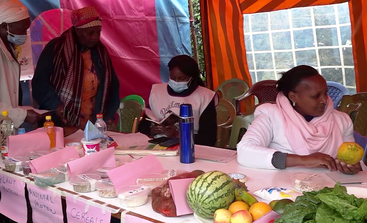 A nutritionist gives advice to a tea farmer at Karumandi health centre for a routine check-up.