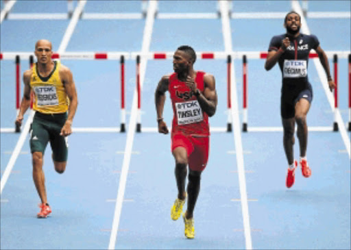 SNEAKING IN: Cornel Fredericks of South Africa, left, finishes fourth behind Michael Tinsley of the US, centre, in the men's 400m hurdles heats in the IAAF World Athletics Championships at the Luzhniki Stadium in Moscow, Russia, yesterdayPhoto: Getty Images