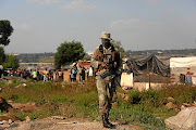 The SANDF soldier on patrol in Alexandra is part of SA's biggest military deployment since 1994./ALON SKUY