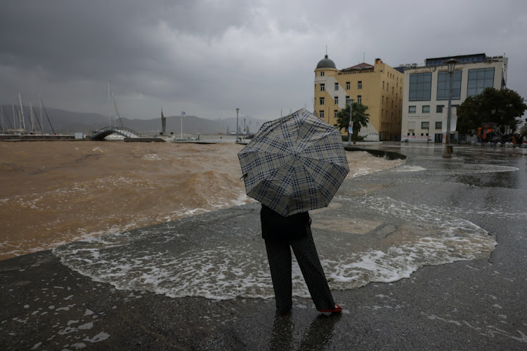 A person holds an umbrella next to the port, as storm Daniel hits central Greece, in Volos, Greece, September 6, 2023.