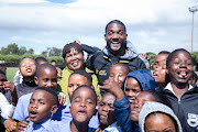 Olympic sprinter Justin Gatlin with kids in Langa, Cape Town, where he and former American hurdles record holder, Sharrieffa Barksdale, were promoting their athletic development organisation Born 2 Be Elite.