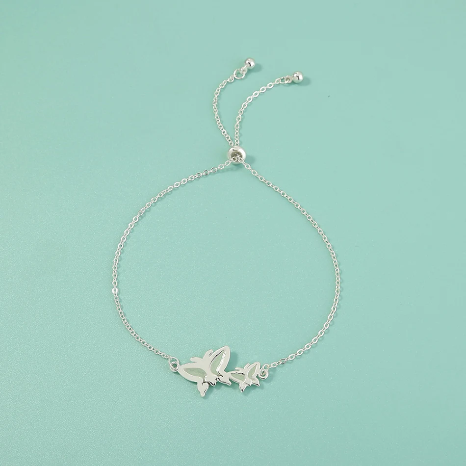 Verstelbare armband met koperen design, zilveren vlinder en fluorescerende elementen, nikkelvrij, voor een unieke uitstraling.