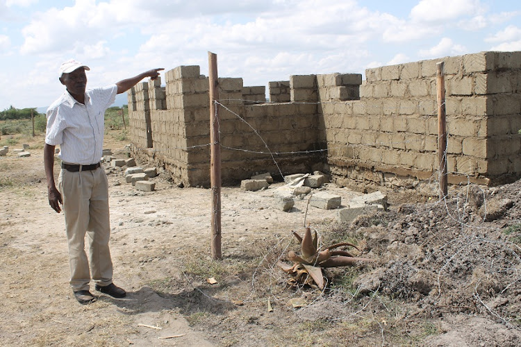 Francis Mwaniki points at a structure being built on disputed land at Komarock in Matungulu, Machakos county, on July 12.