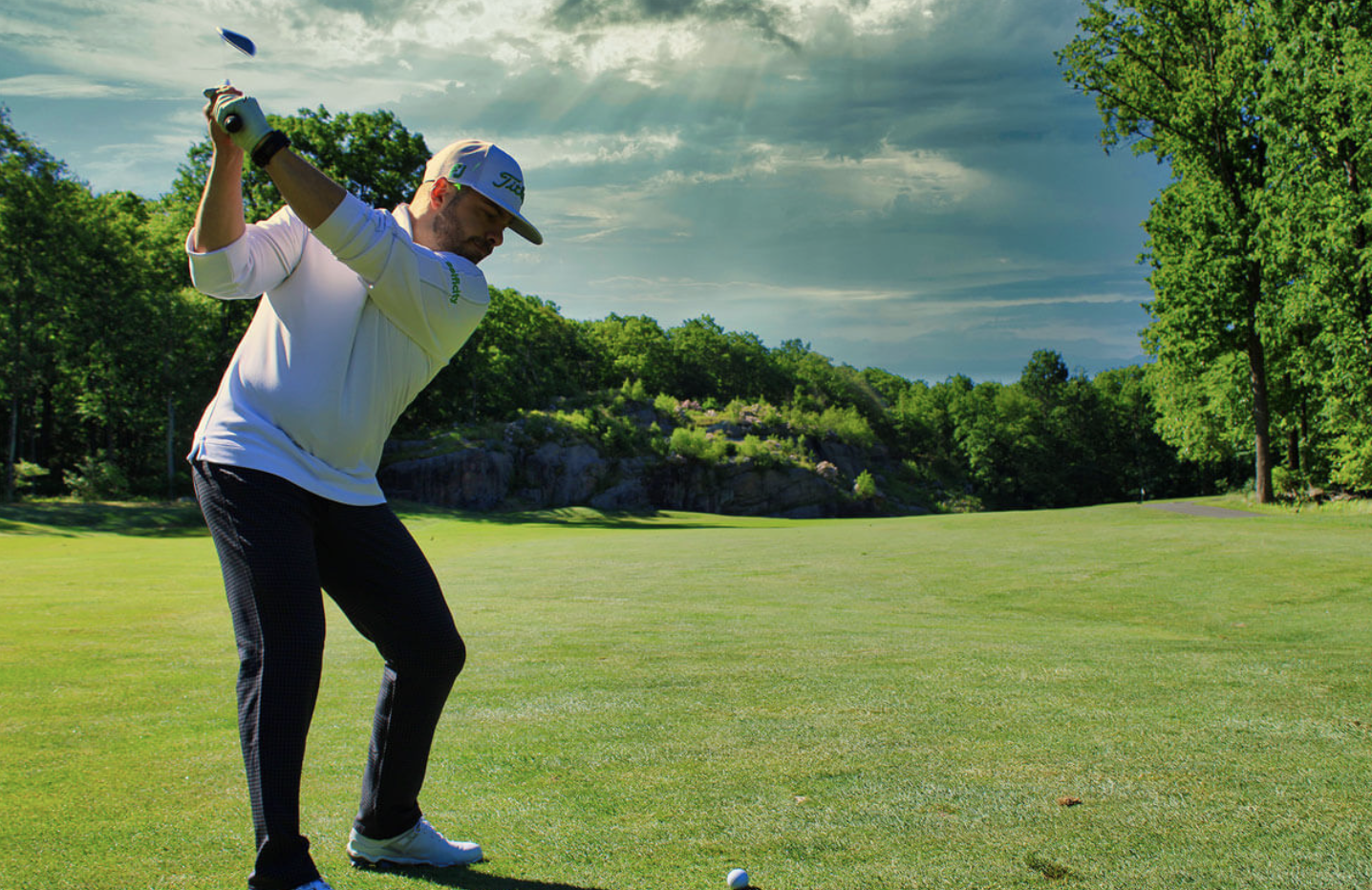 Man golfing about to hit a fade