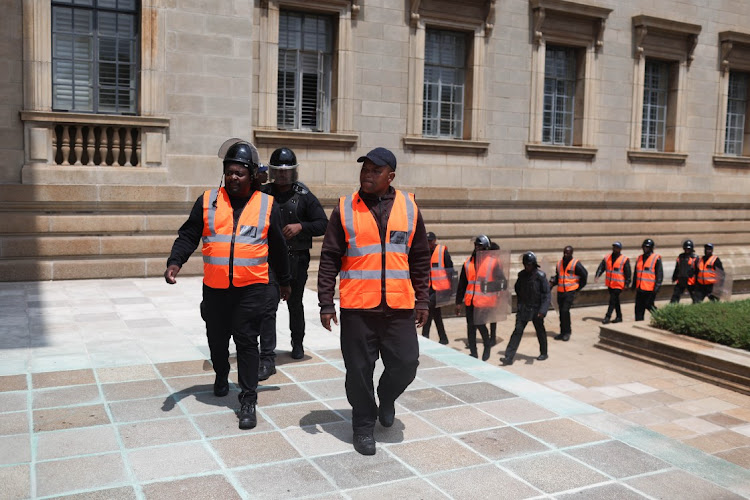 Security officers make their way in as protesting students rush to enter the University of the Witwatersrand's Great Hall on March 3 2023 in Johannesburg.