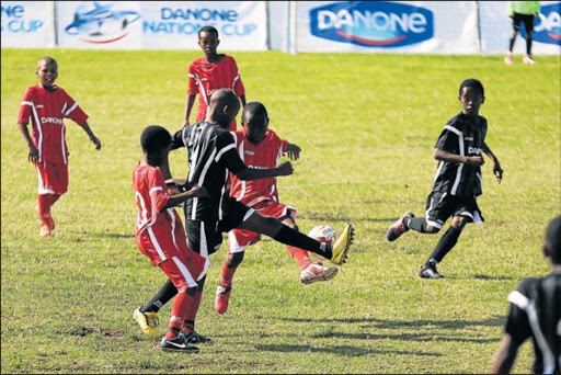 FAIR PLAY: Youngsters from Qumbu Village (red) and Siyaphambile from Nelson Mandela Bay challenge for the ball during the Danone cup challenge held at Sisa Dukashe Stadium over the weekend. Picture: ALAN EASON