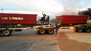 A group of youth use a truck to barricade a road over the demolition of houses at  Nomzamo Park.