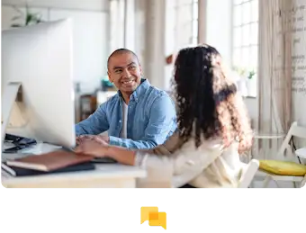 Deux personnes travaillent en étroite collaboration devant un grand écran.