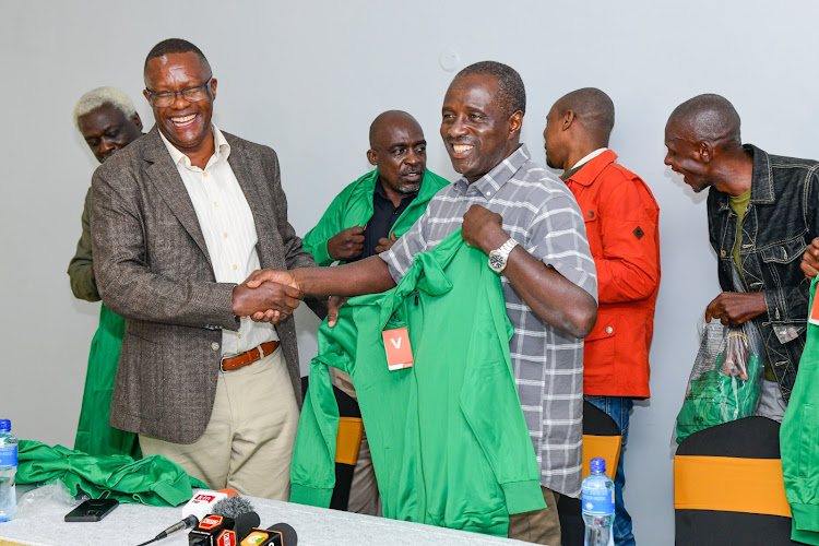 ICT Cabinet Eliud Owalo presents a track suit to former Gor Mahia captain Austin Oduor Makamu as other retired players look on