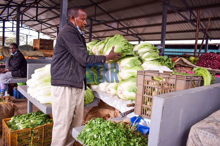 Julius Kirei organises some of the vegetables he sells at City Park Market, Parklands on July 25, 2021.