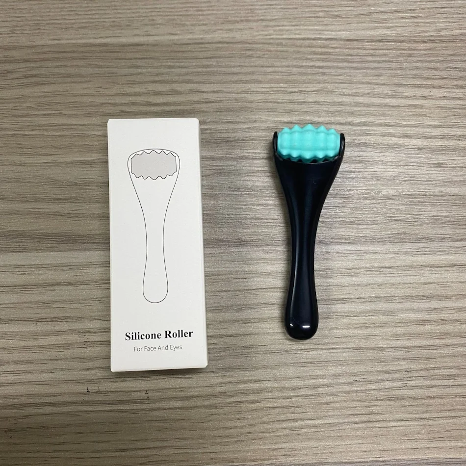 Massageador portátil para olhos com rolo de silicone e creme, reduz olheiras e rugas, promove pele fresca e rejuvenescida, fácil de usar.