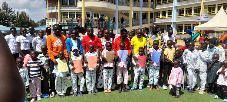Amos Kipruto (in red jacket) when he joined other athletes from 2Running club at the Shoe4Africa Children's Hospital in Eldoret.