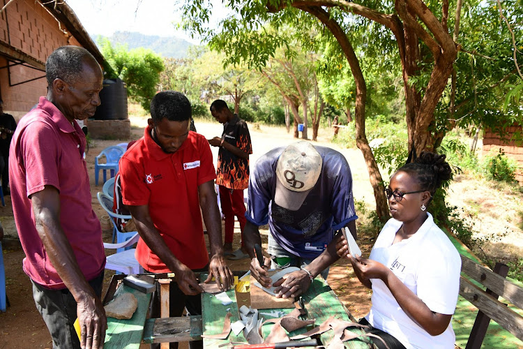 Youths cut leather at their workshop in Mwatate. More than 25 youths are engaged in the leather craft