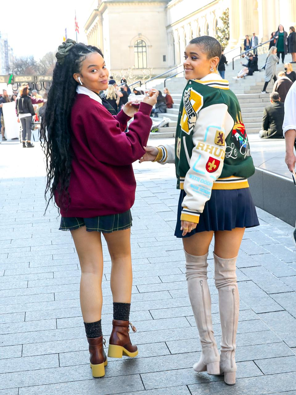 2 ladies wearing sweater and jacket over their micro mini skirt outfits