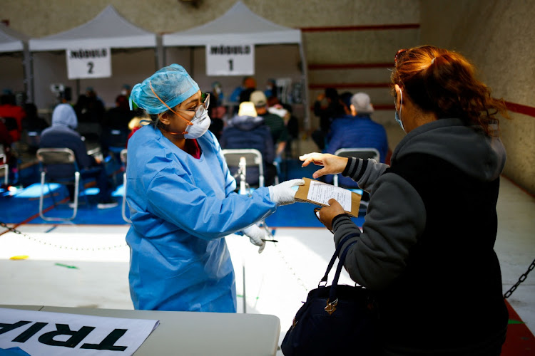 A health worker attends to a person in a gym set up as a Respiratory Care Module where workers of the Mexican Social Security Institute (IMSS) grant sick leaves to patients with Covid-19 in Ciudad Juarez, Mexico, on January 19 2022.