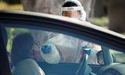 A healthcare worker at LAC USC Medical Center tests a person at a drive through testing center during the outbreak of the coronavirus disease in Los Angeles, California, US on December 10 2020. 
