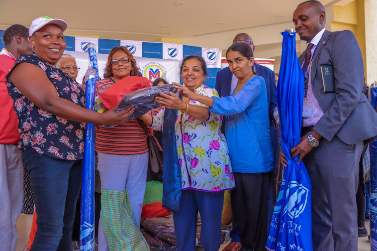 Zetech University, Crime Si Poa – Youth Safety Awareness Initiative and Oshwal Mahila Mandal officials giving out donationas to Witeithie residents in Juja.