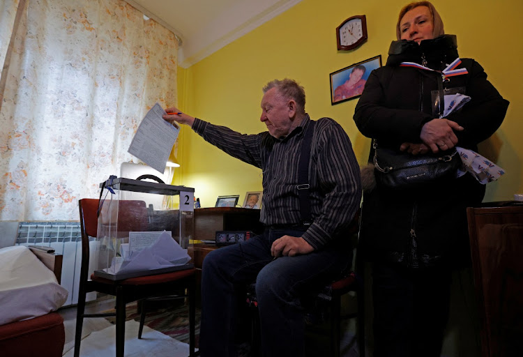 A man casts a ballot into a mobile ballot box at his home as members of an electoral commission visit residents during the early voting in Russia's presidential election, on March 11 2024. Picture: REUTERS/ALEXANDER ERMOCHENKO