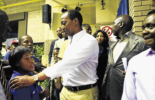 MONEY TALKS: Mining magnate Patrice Motsepe greets Mbali Munano at the Tshwane University of Technology on a leg of the Motsepe Foundation's road show in September 2013. The foundation wants to give about R200-million to the poor by June 20, 2013. Picture: LAUREN MULLIGAN