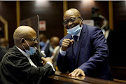 Former president Jacob Zuma shares a light moment with a member of his legal team at the Pietermaritzburg high court.