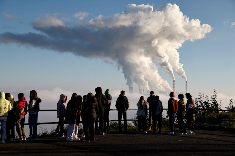 People watch smoke and steam billow from Belchatow Power Station, Europe's largest coal-fired power plant powered by lignite, in Zlobnica, Poland, October 20 2022. Picture: KUBA STEZYCKI/REUTERS