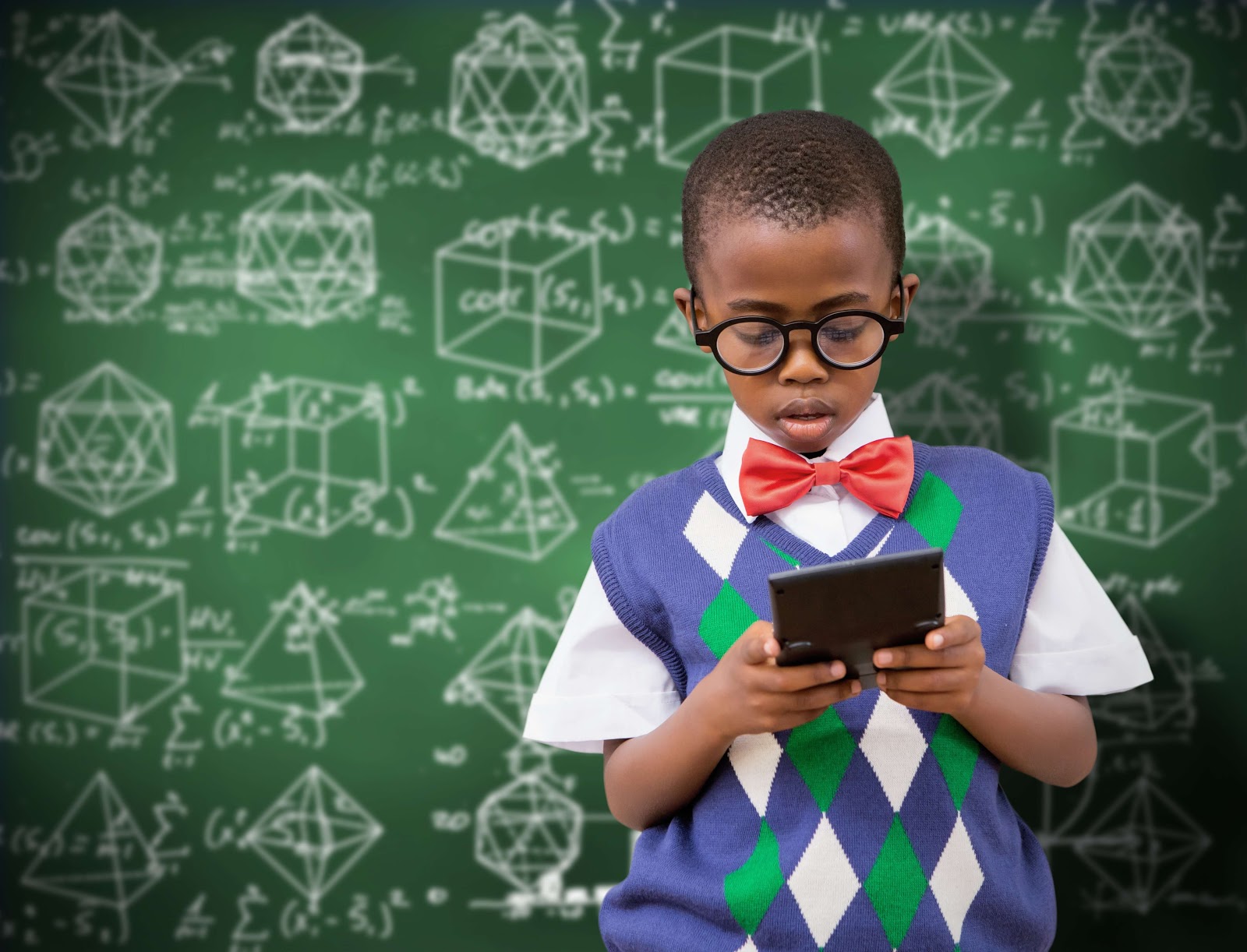 A kid holding a calculator in front of a blackboard