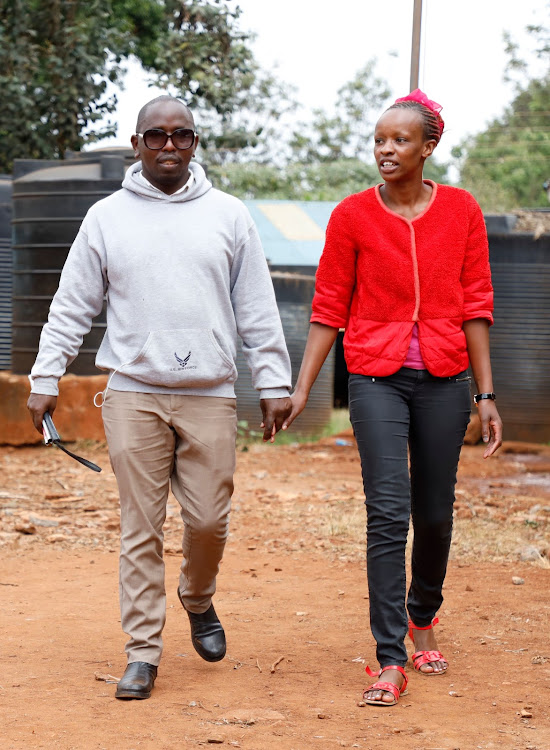 Kamau Mbugua walks with his assistant Shelmith Wangu at Gitiba Primary School